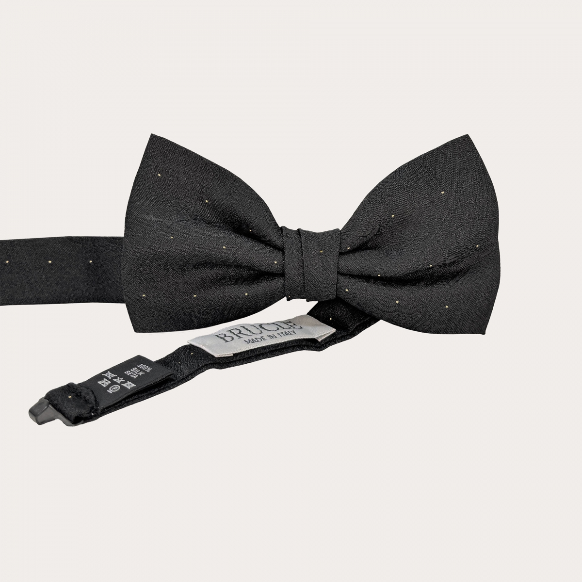 Black silk bow tie with tone-on-tone paisley pattern and gold stick pin